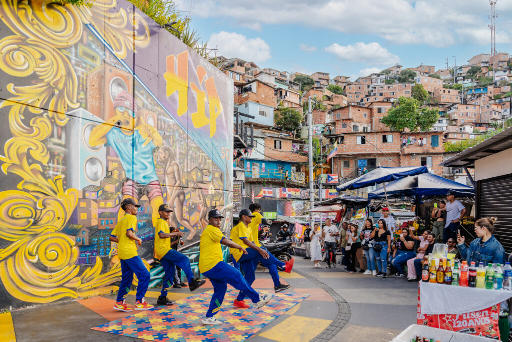 Grupo de baile urbano en graffiti tour Comuna 13 Medellín con murales coloridos