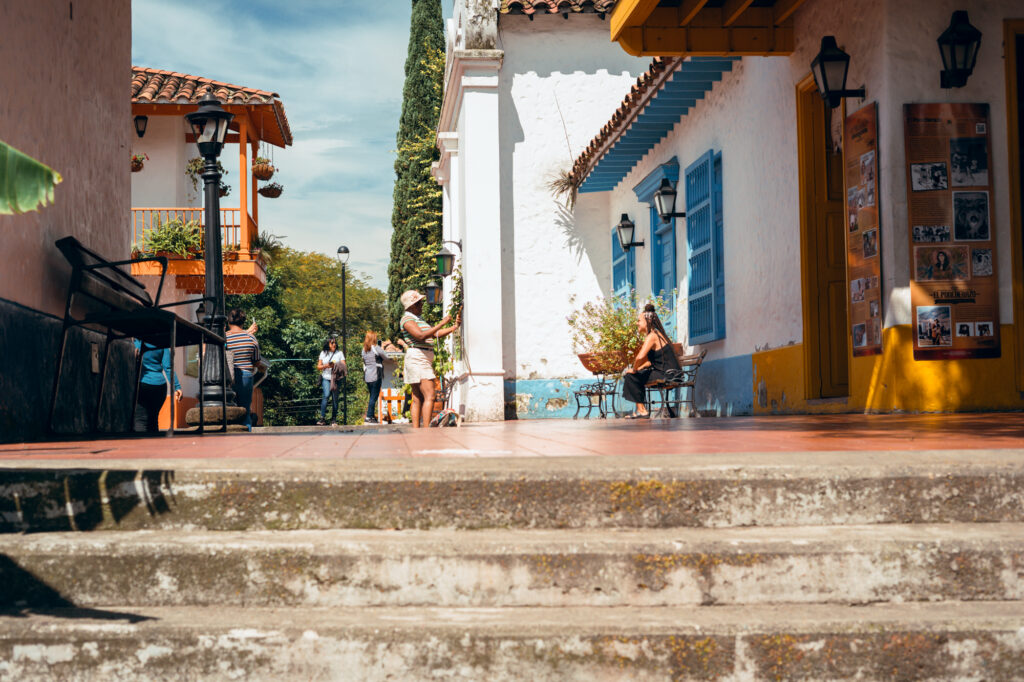 Calle y casas tradicionales del Pueblito Paisa en el Cerro Nutibara de Medellín con visitantes recorriendo el lugar