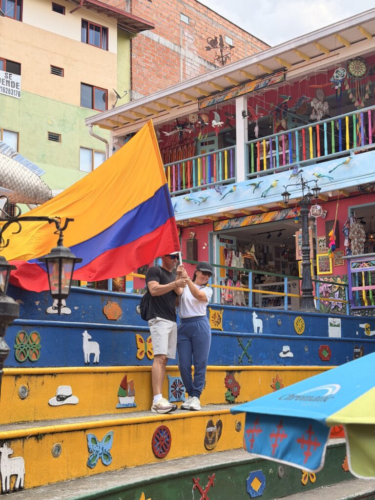 Turistas con bandera de Colombia en pueblo tradicional de Antioquia