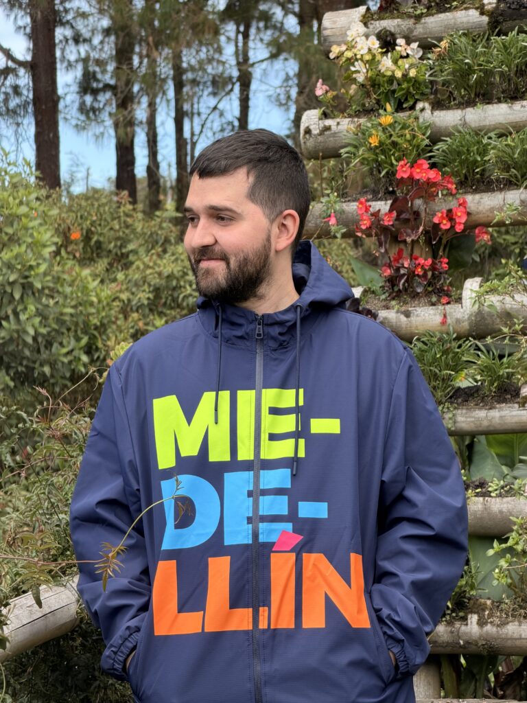 Rompevientos unisex Medellín azul oscuro con diseño tipográfico multicolor