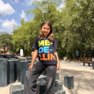 Camiseta infantil Medellín azul oscuro con diseño tipográfico colorido estilo urbano.